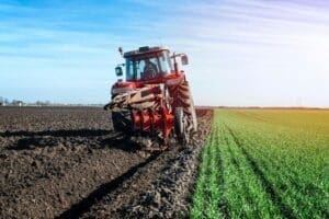 Máquina pesada fazendo colheita na Agricultura Intensiva em uma grande fazenda