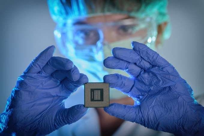 Uma cientista segura uma placa eletrônica para observar as nanopartículas